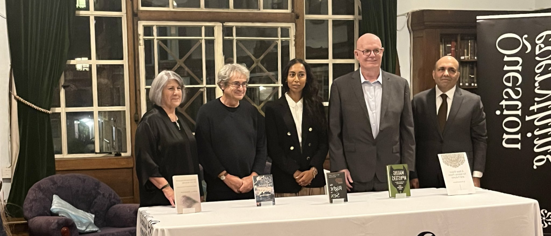 A photo of the prize finalists standing behind a table bearing the Royal Institute of Philosophy's name and logo